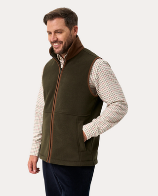 Hombre vistiendo chaleco polar Beviá Aylsham verde con ribetes marrones y cremallera frontal sobre camisa a cuadros