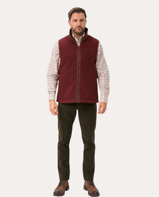 Hombre vistiendo chaleco polar burdeos Alan Paine de Beviá sobre camisa de cuadros y pantalones oscuros