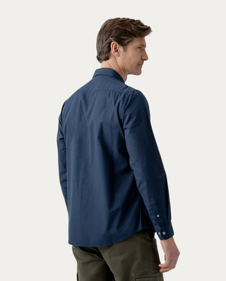 Hombre de espaldas vistiendo camisa Beviá Oxford azul marino de algodón con acabado desgastado y corte regular fit