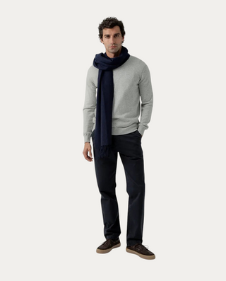 Modelo vistiendo jersey Beviá de cuello de pico en color gris con bufanda azul marino y pantalones oscuros