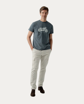 Hombre vistiendo camiseta Beviá azul grisáceo de algodón con estampado gráfico de moto y cuello redondo